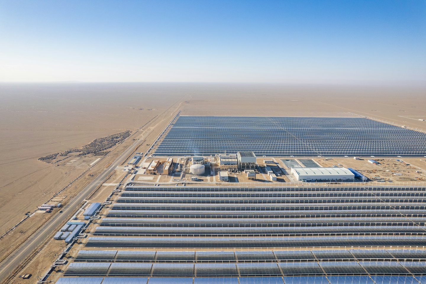 Rows of solar panels span a vast desert landscape.