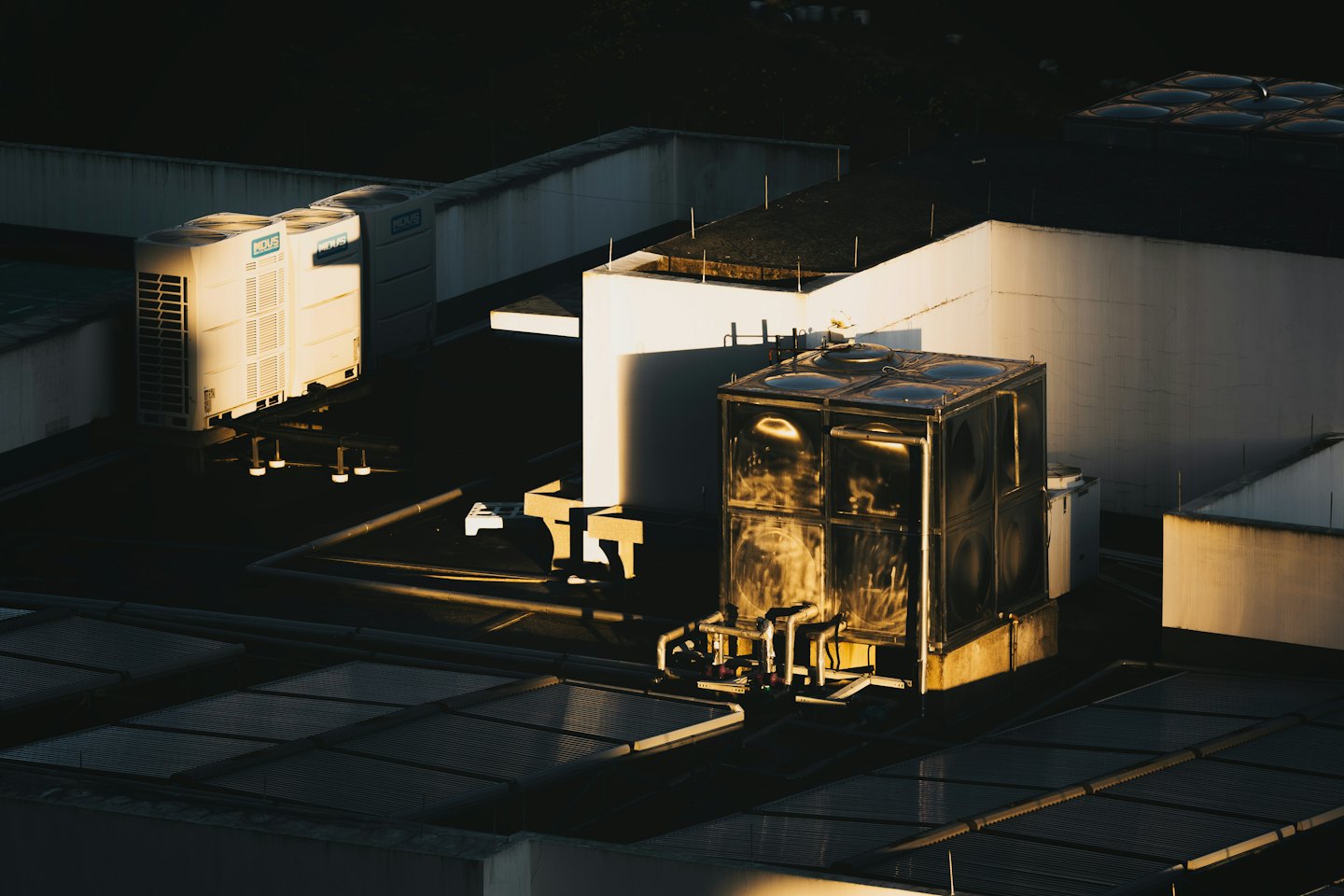 Industrial rooftop with air conditioning units and water tank.